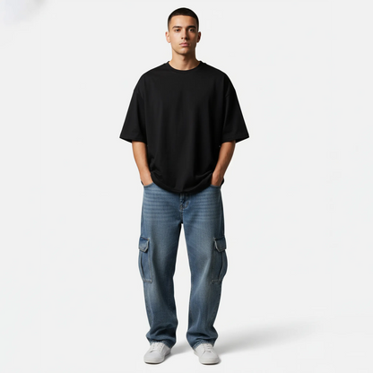 Man wearing a black t-shirt and blue jeans on a white background