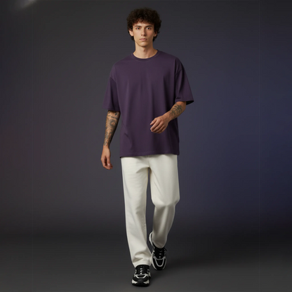 Person wearing a purple shirt and white pants against a gradient background
