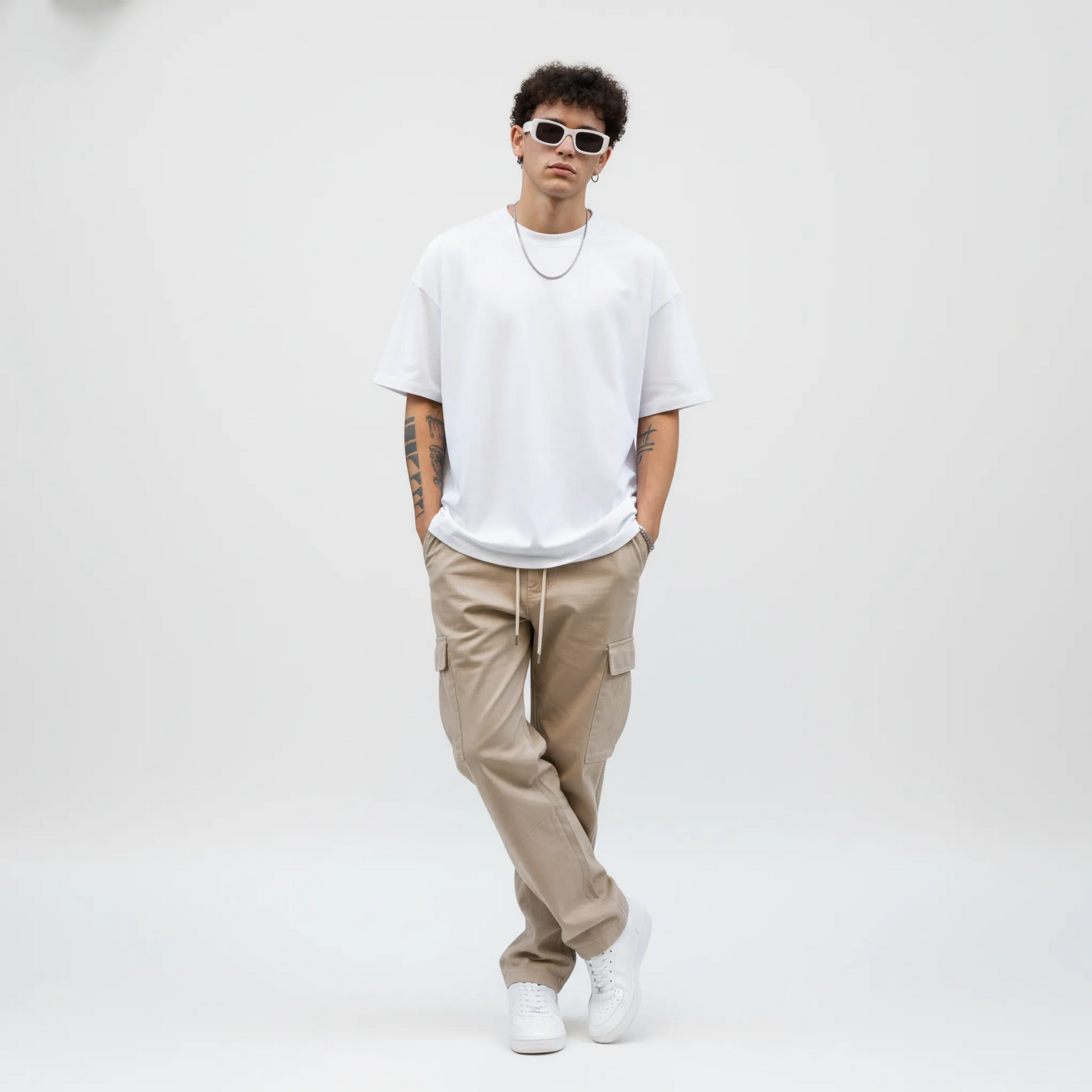 Person wearing a white t-shirt, beige cargo pants, and white sneakers on a plain background