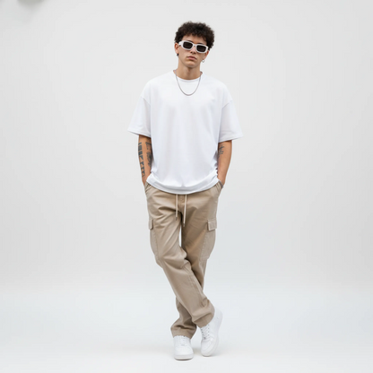 Person wearing a white t-shirt, beige cargo pants, and white sneakers on a plain background