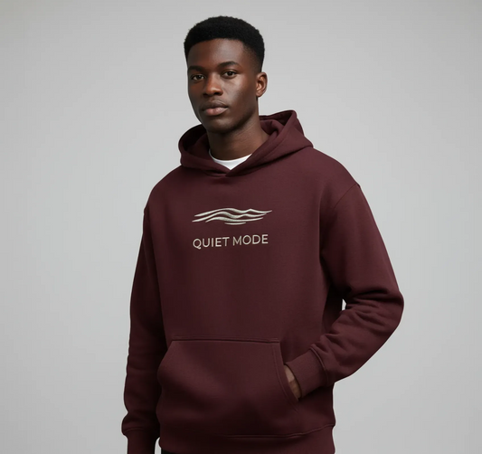 Person wearing a maroon hoodie with 'Quiet Mode' text and wave design on a gray background