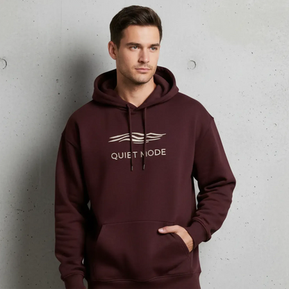 Man wearing a maroon hoodie with 'Quiet Mode' text against a gray background